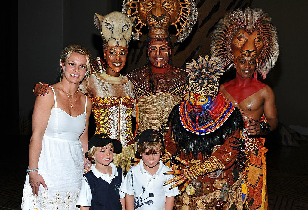 Britney smiling awkwardly as she and her sons pose with the cast