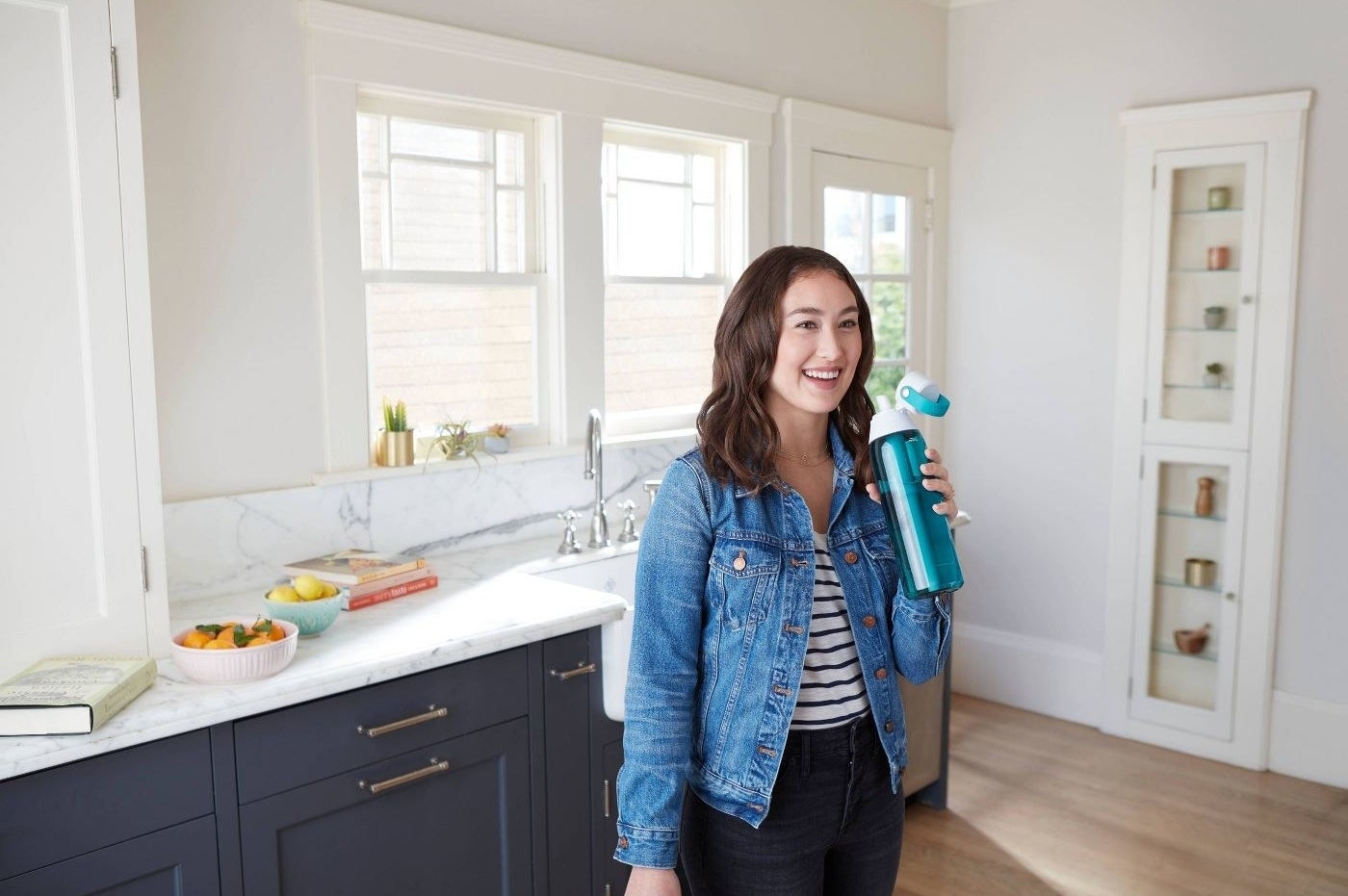 Model sipping water from blue water bottle