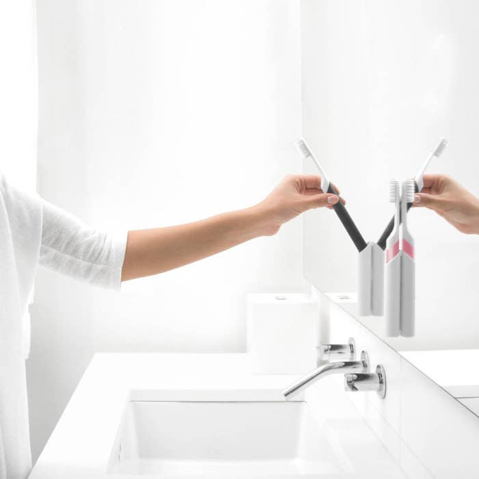 Model putting toothbrush away in bathroom