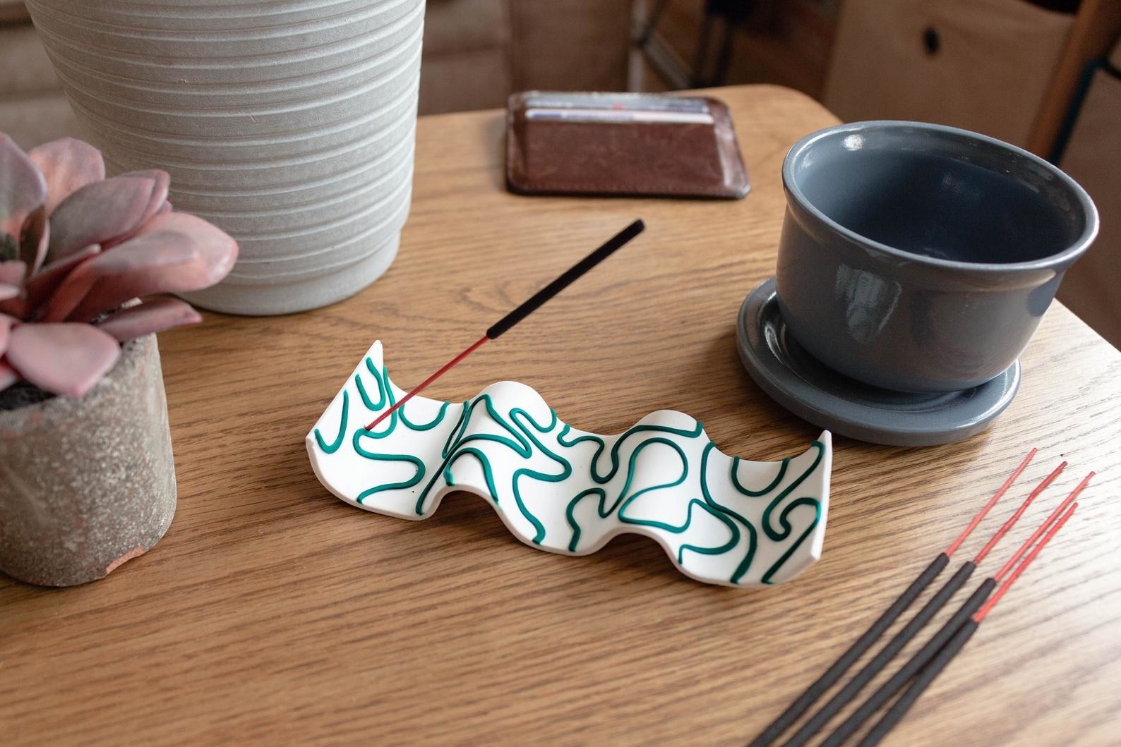 the white and teal curved incense holder