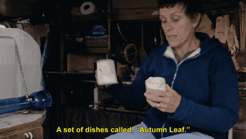 McDormand pulling out a small tea pot and matching cup that have autumn-colored leaves printed on them