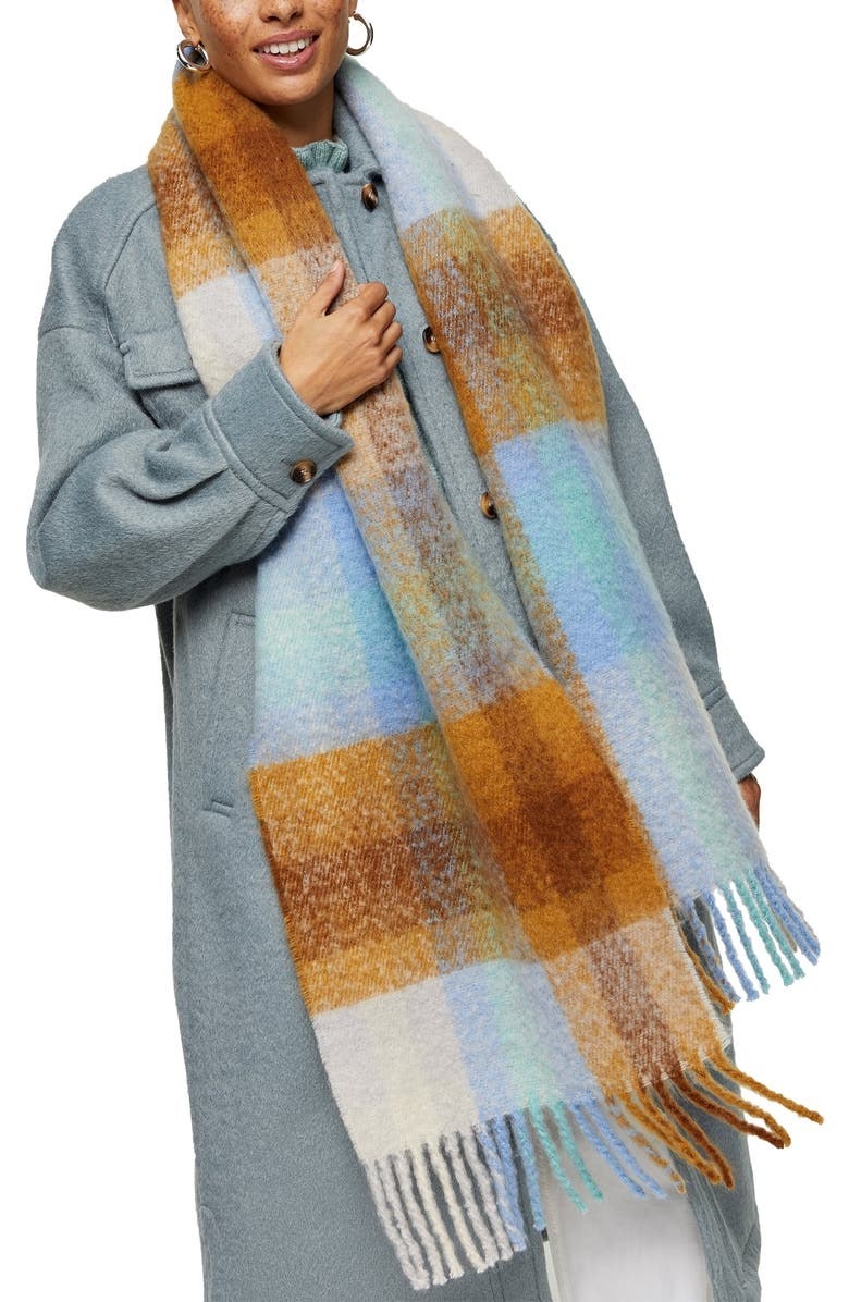 model wearing a blue brown and white plaid scarf