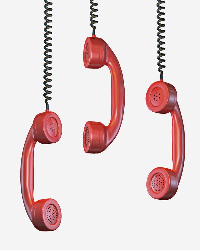 Three red phone receivers hanging in the air