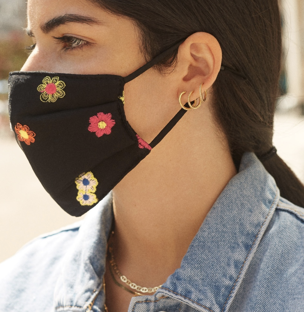 Model in black face mask with flower embroidery