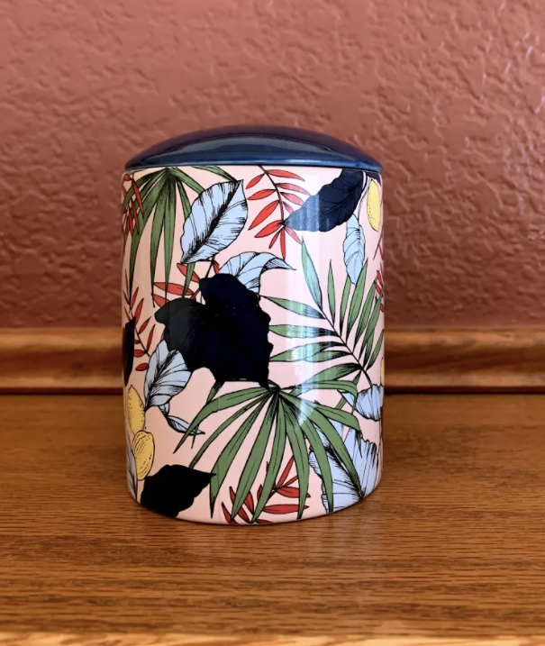 kit's candle in a pink, palm, and floral pattern container