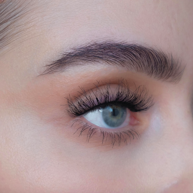 A close up of a person wearing the false lashes and showing off the fluffy texture