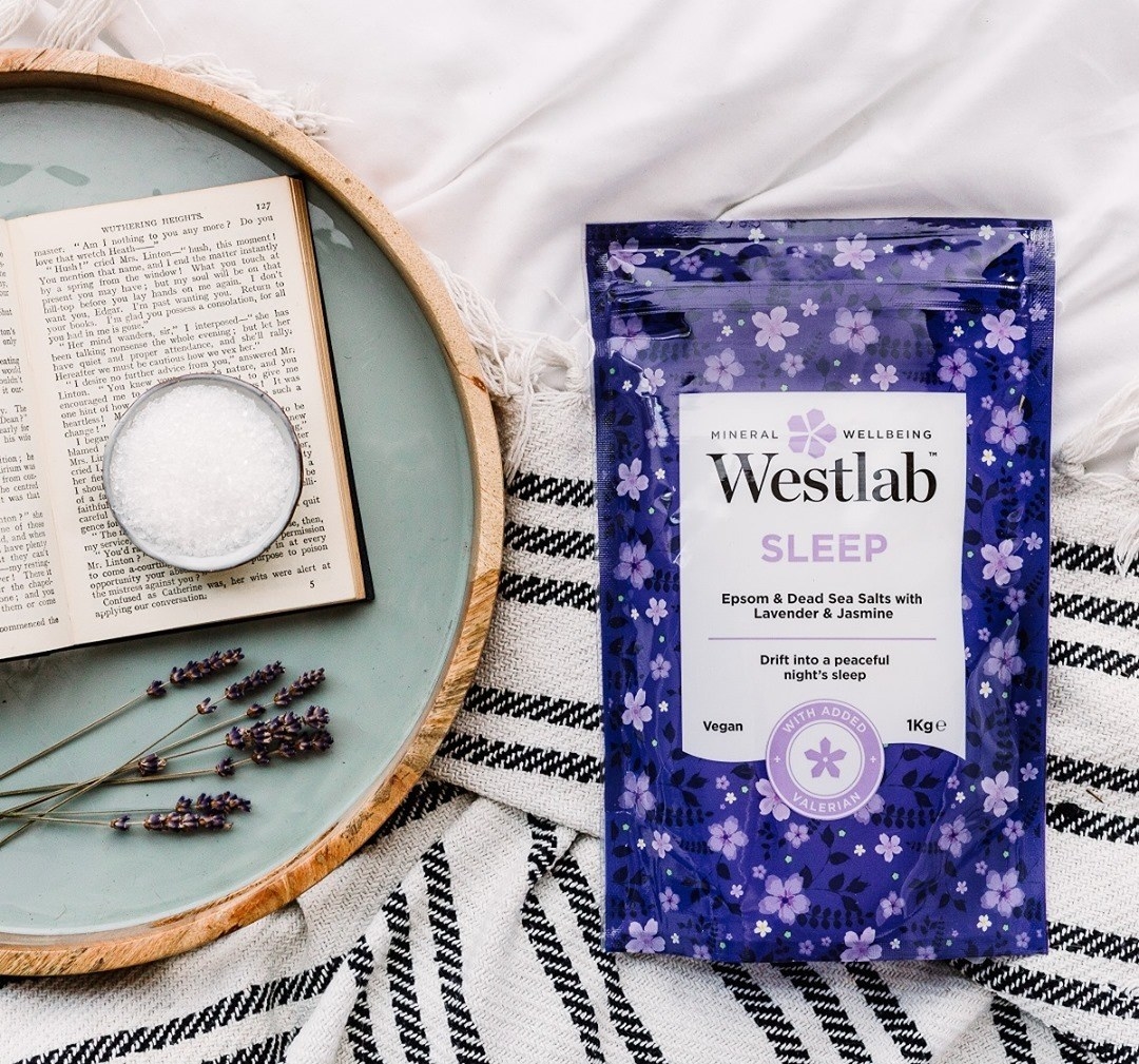 A flatlay of the bath salts on a blanket next to an open book