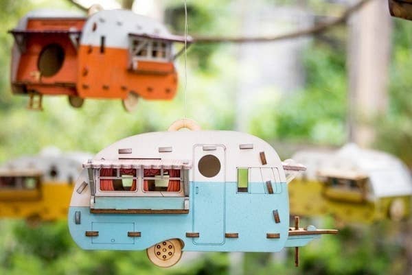 Four different camper bird houses hanging outside