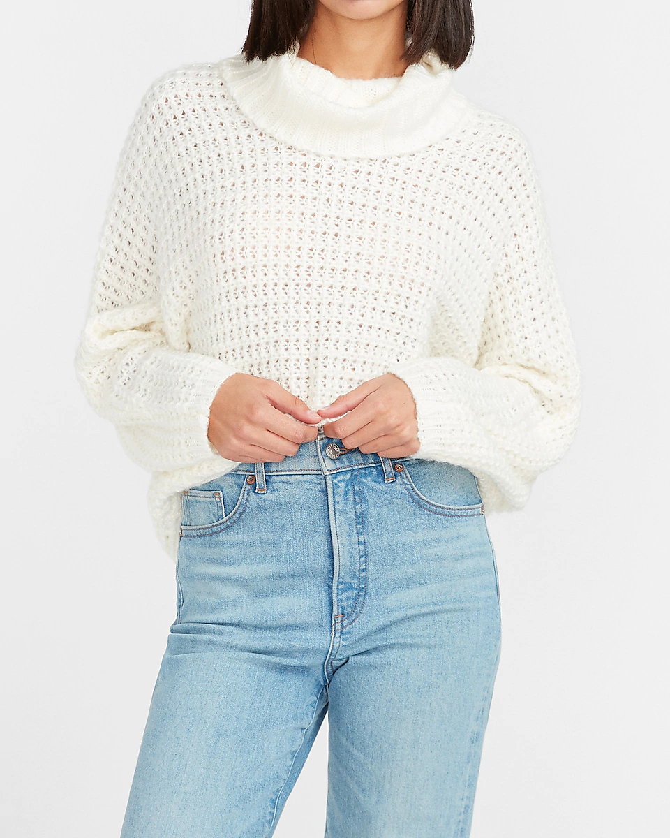 model wears mockneck sweater with wide knit pattern