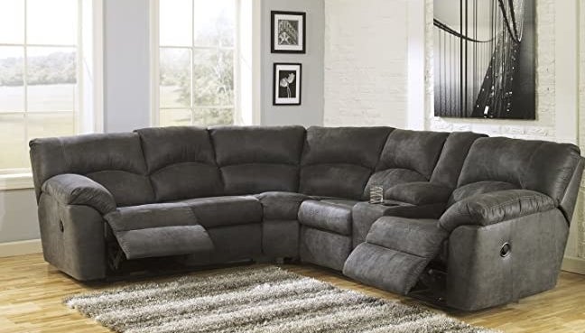 A dark gray L-shaped sectional with both the end seats in a reclining position and two cup holders by the right-most seat 