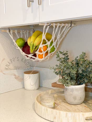 Fruit in the hammock hanging from some cabinets