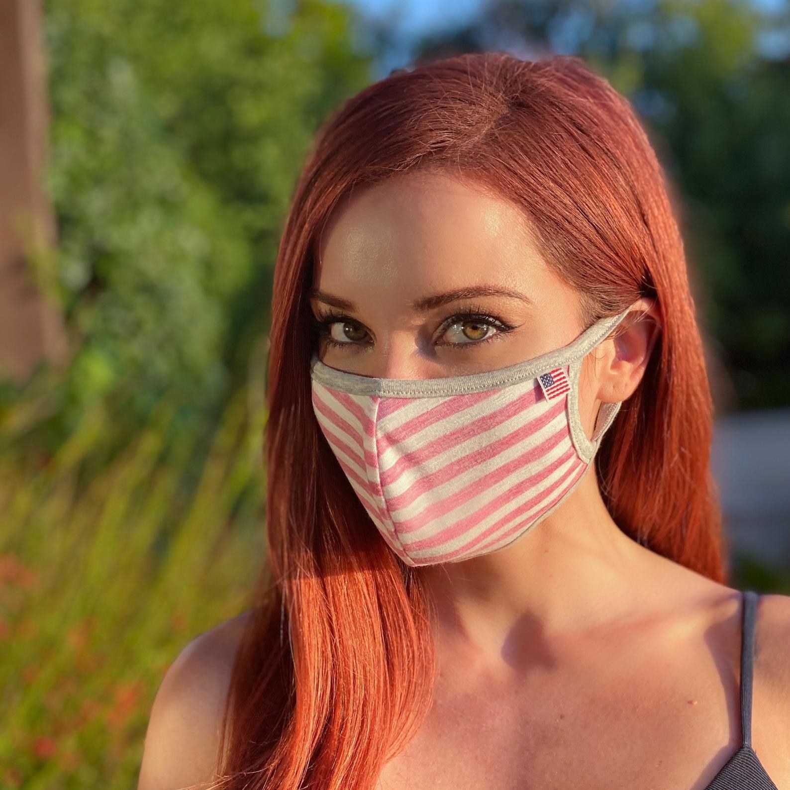 A model in a white and pink striped face mask