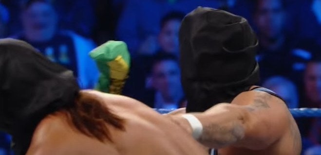Two wrestlers inside a ring with black bags over their heads.