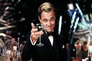 Gatsby holding up a glass of wine with a background full of fireworks
