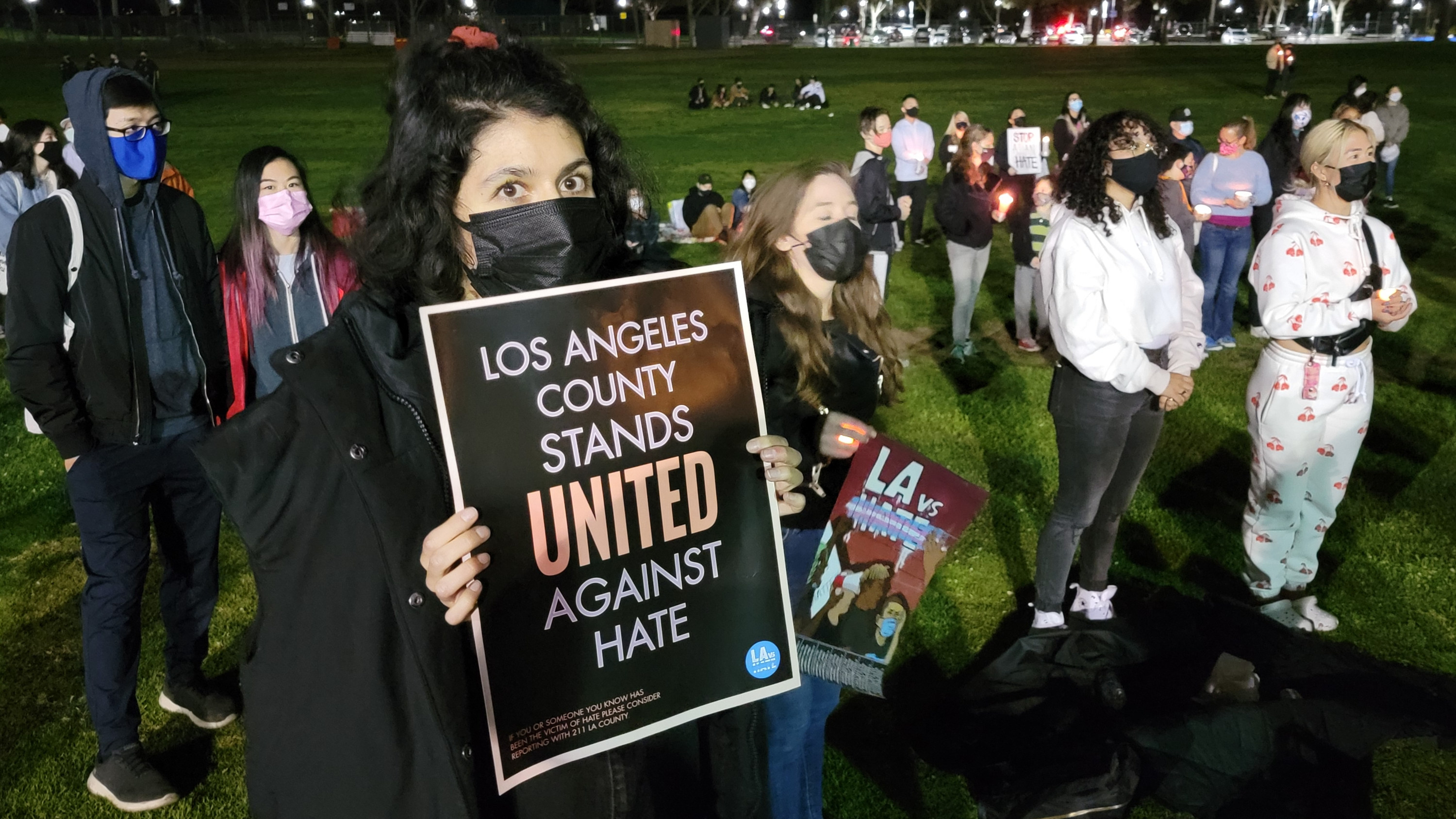 Woman holds a sign reading, &quot;Los Angeles County stands united against hate&quot;