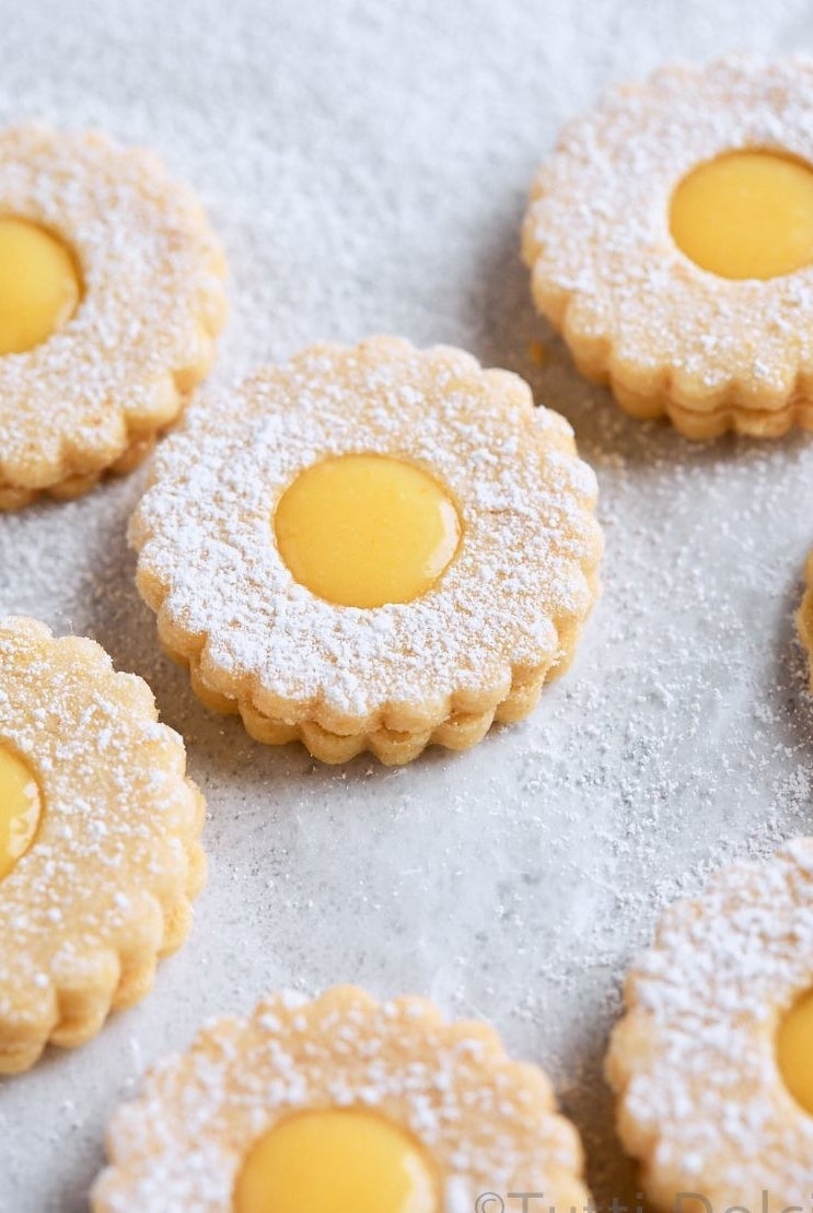Lemon linzer tart cookies with powdered sugar.