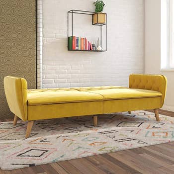 the yellow futon unfolded to create a mattress