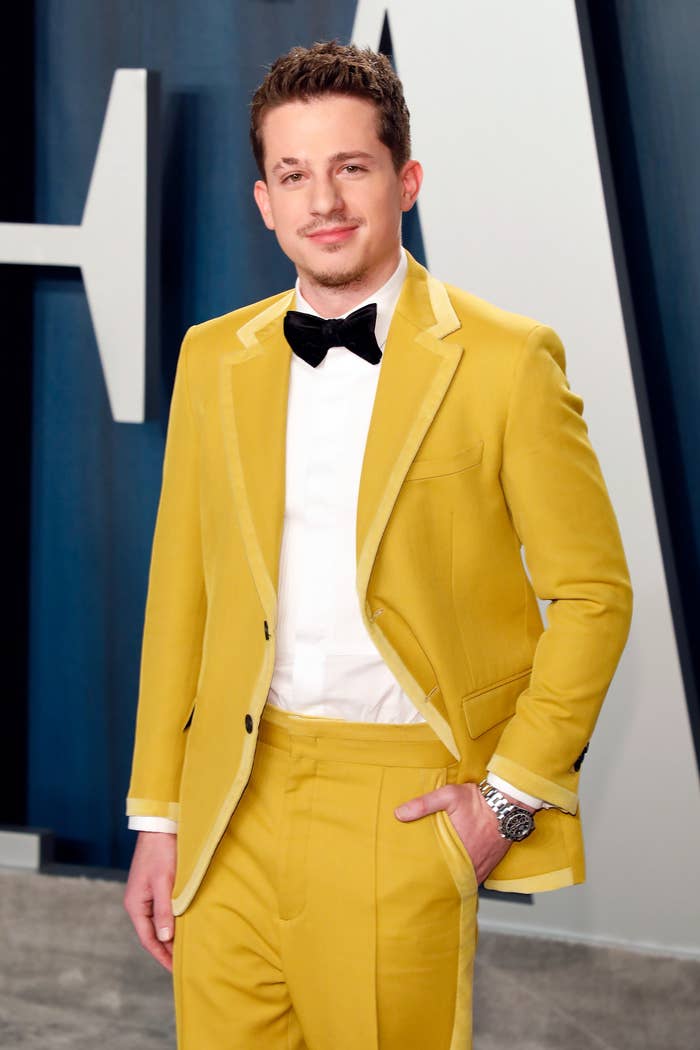 Charlie Puth wearing a bright suit with a bow tie and a watch