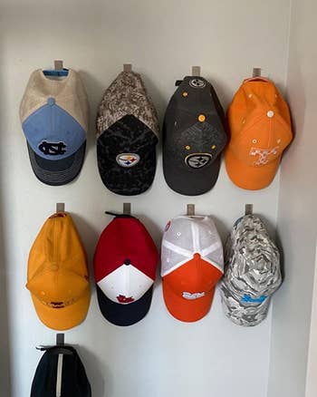 Reviewer showing their nine baseball caps hanging neatly on the wall hooks