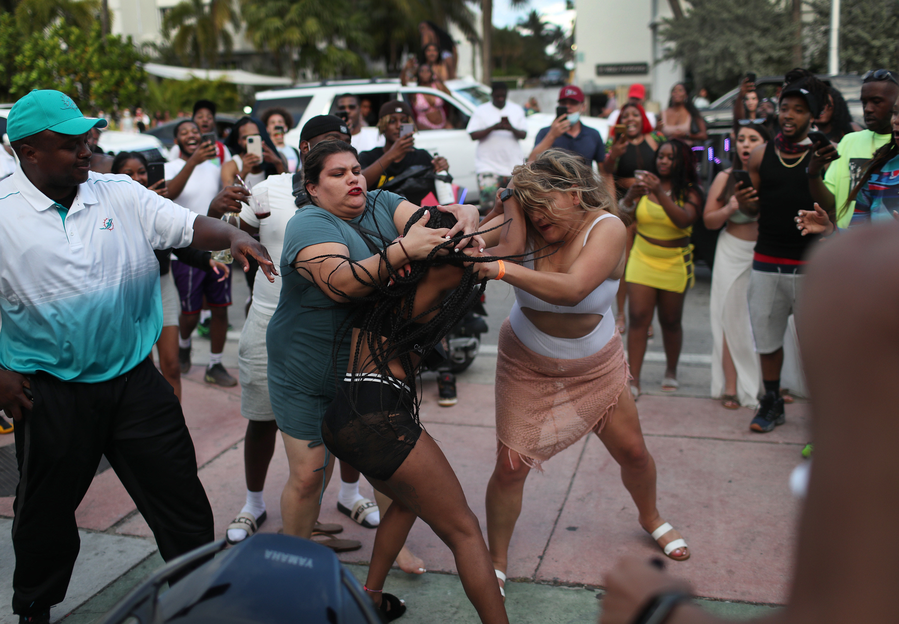 Three women fight while the crowd films it