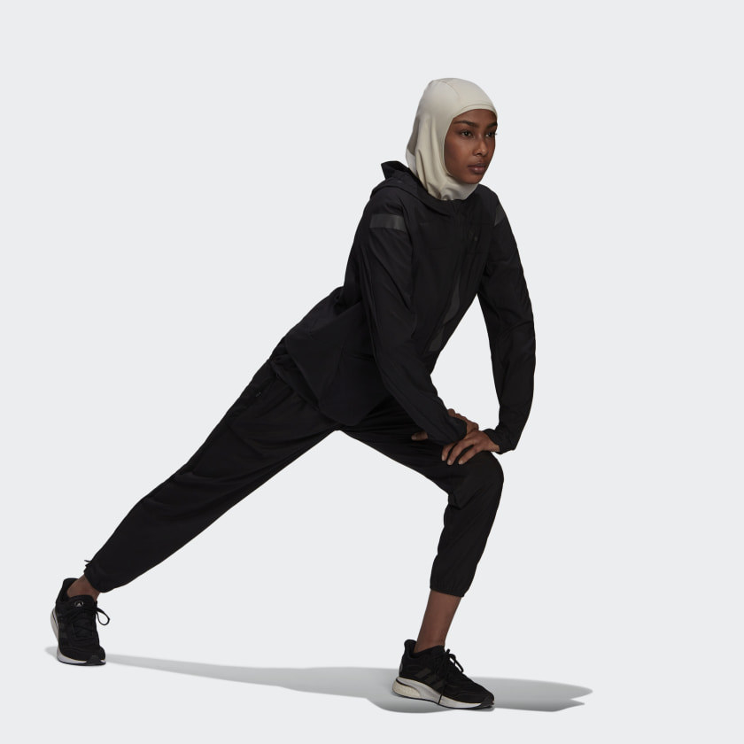 Model wearing khaki colored hijab with reflective adidas logo