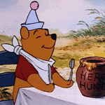 Winnie the Pooh dancing happily at a table with utensils and honey