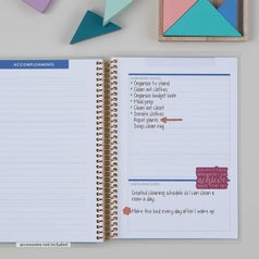 An open notebook with pages titled "accomplishments"