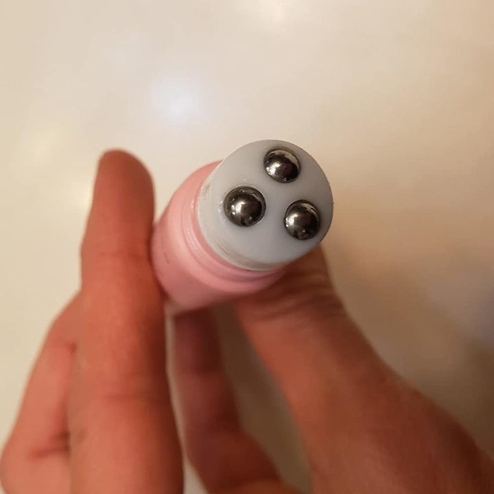 a reviewer photo of a hand showing the three silver roller balls on the tip of the product 