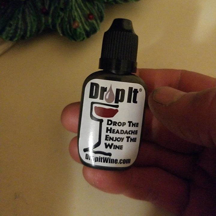 a reviewer photo of a hand holding the "Drop It" dropper bottle 
