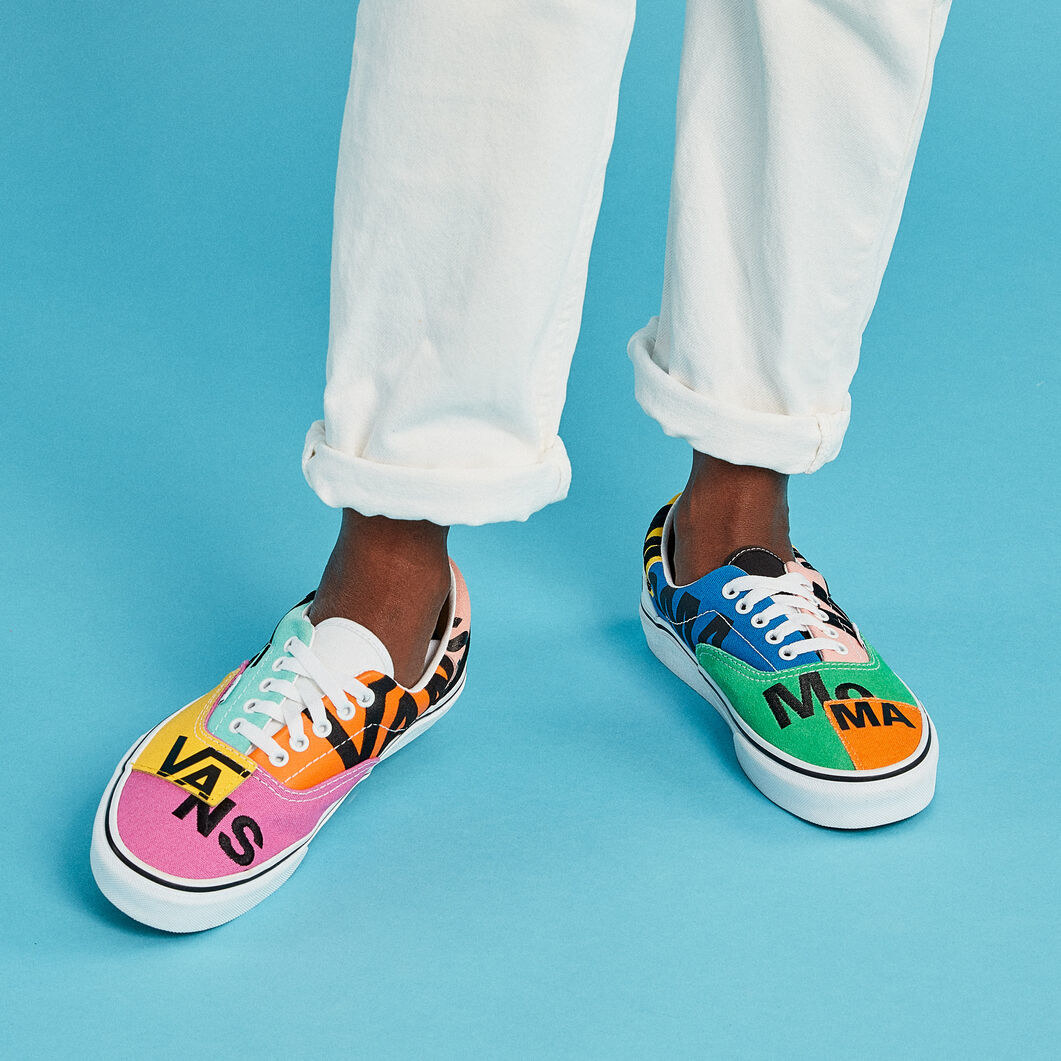 a model wearing the colorful moma vans sneakers with white pants