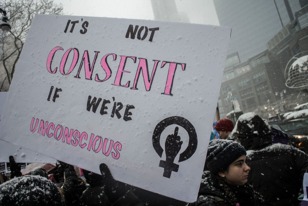 a protest sign that reads: &quot;it&#x27;s not consent if we&#x27;re unconscious&quot;