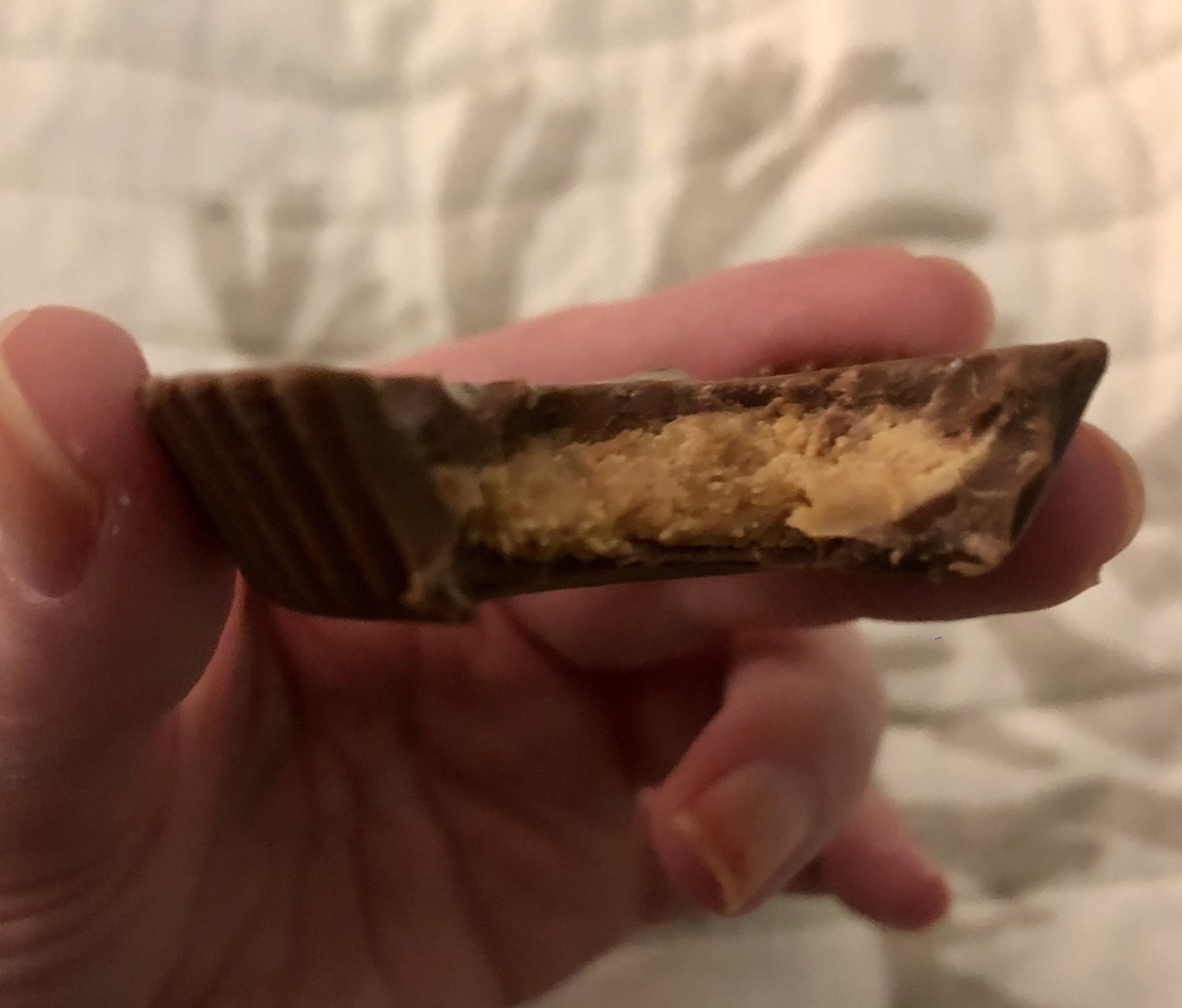 BuzzFeed Editor holding a bitten-into organic reese&#x27;s cup