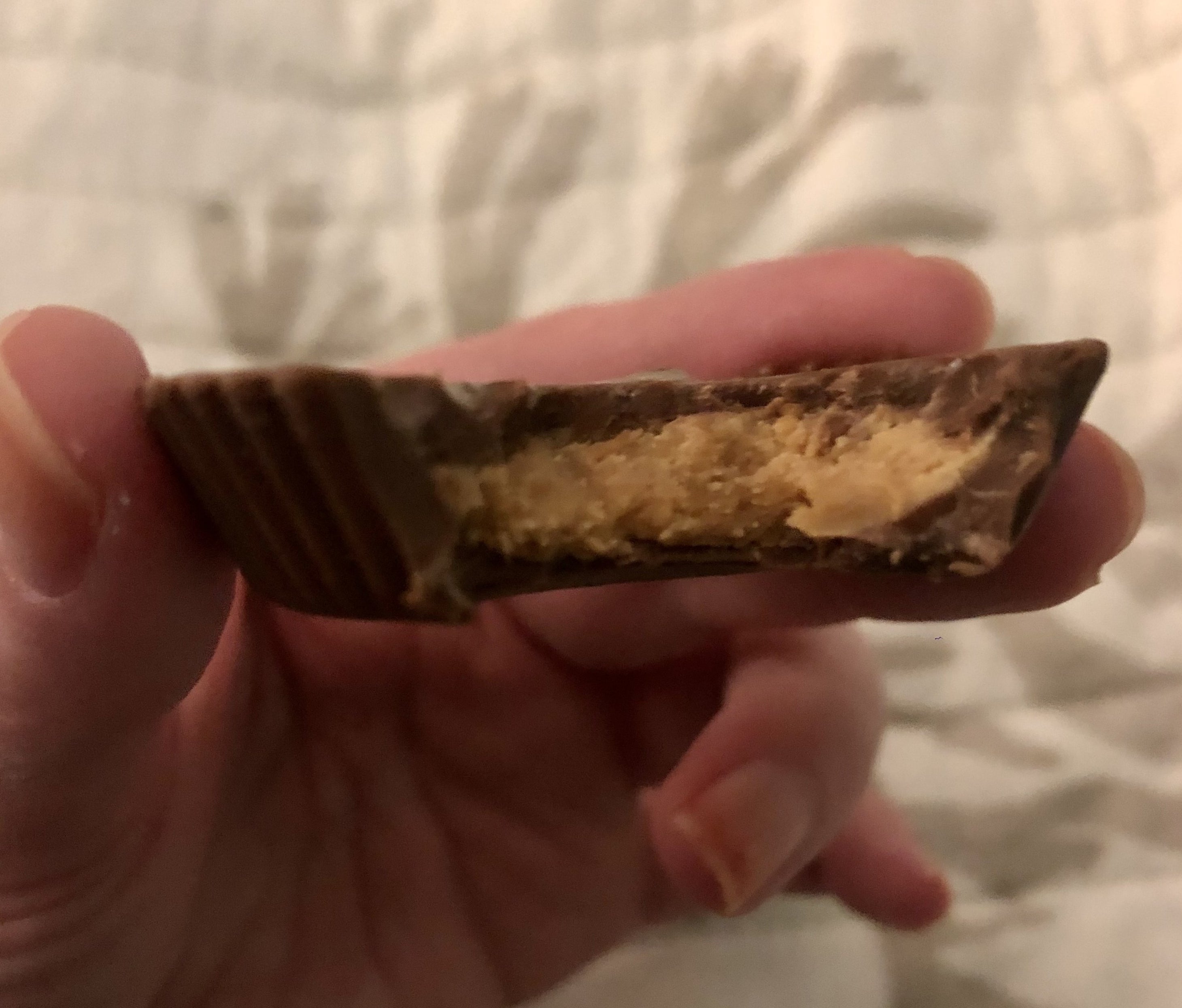BuzzFeed Editor holding a bitten-into organic reese's cup