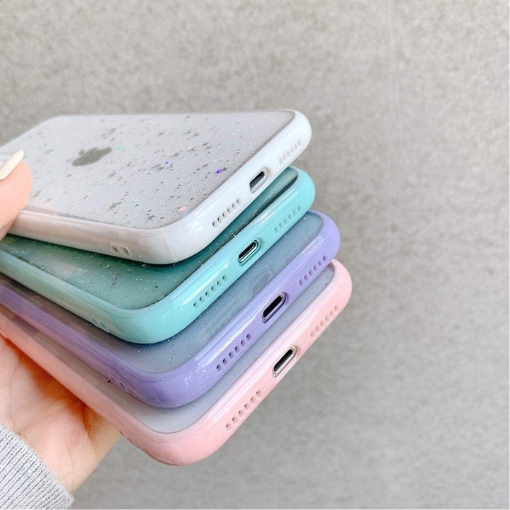 a model holding four phone cases with different pastel colors around the edges