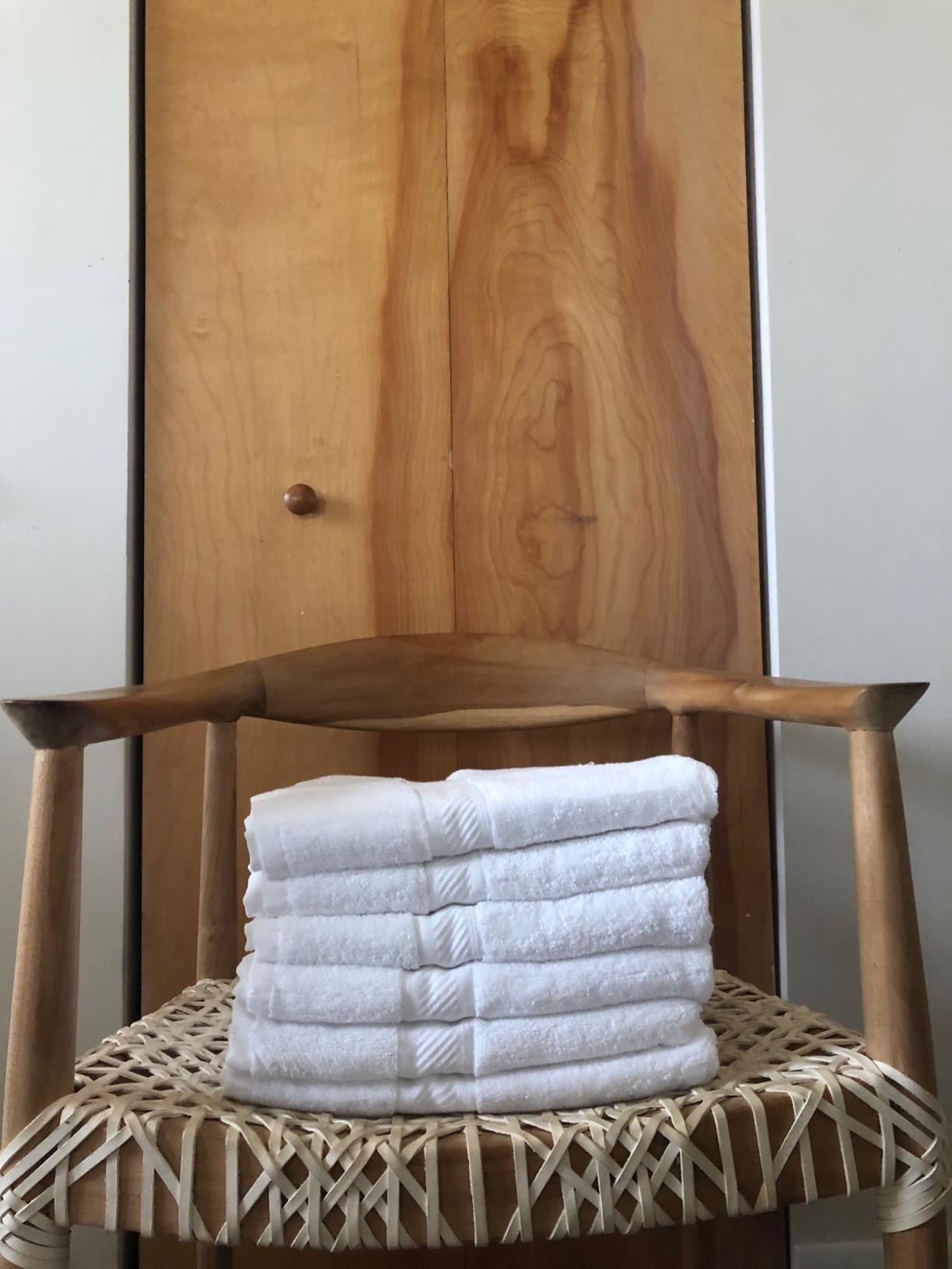 The towels in a stack on a chair