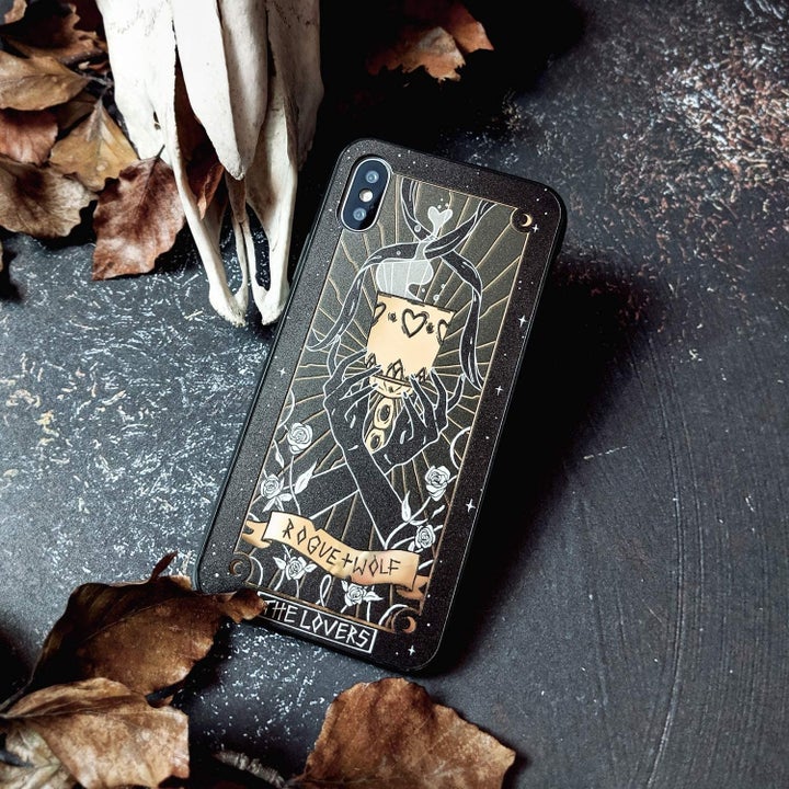 a "lovers" tarot card design on a black case with gold metallic accents