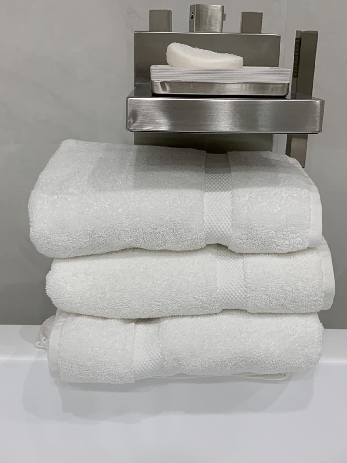 The white towels on the edge of a tub