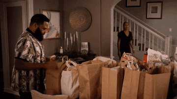 Characters unpacking a bunch of grocery bags in their kitchen