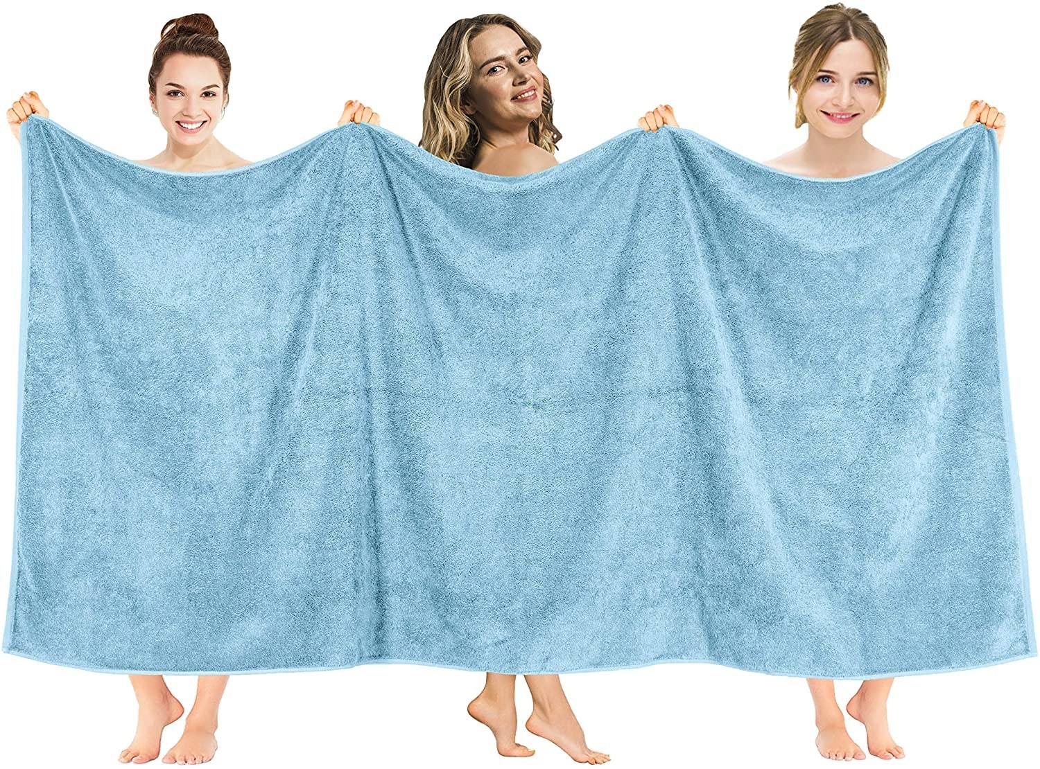 Three women holding up the extra large towel