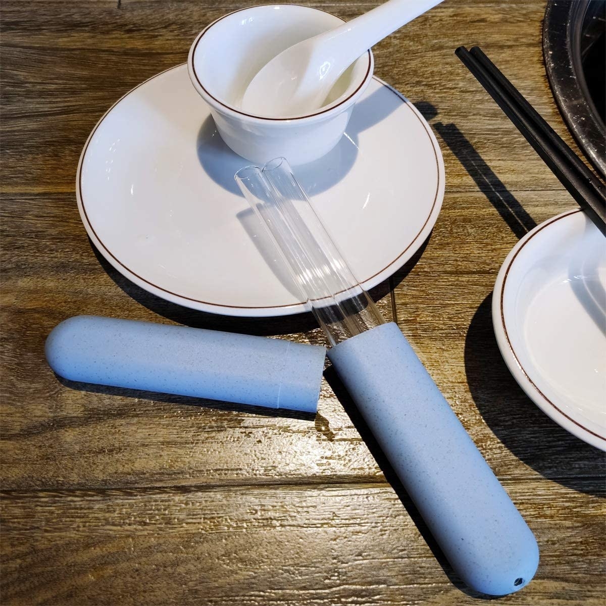 The straws in their case leaning on a tea saucer