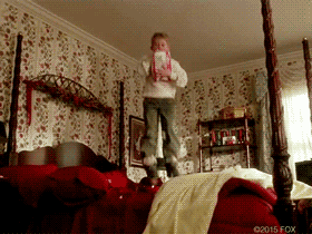 GIF of Macaulay Culkin from Home Alone jumping on the bed.