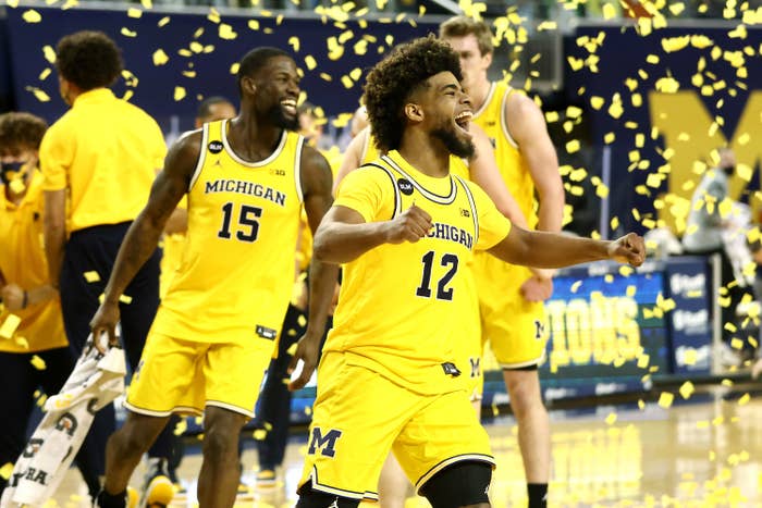 Michigan basketball players celebrating in confetti.