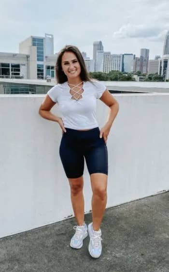 reviewer wearing a white top and black biker shorts