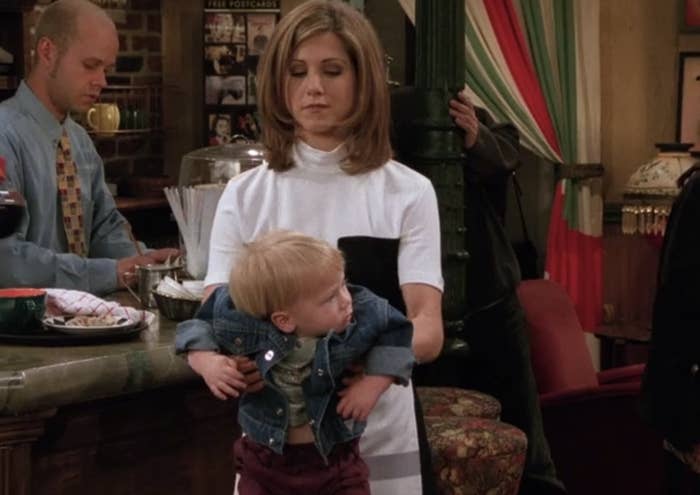 Rachel from &quot;Friends&quot; holding Ben like a football in Central Perk