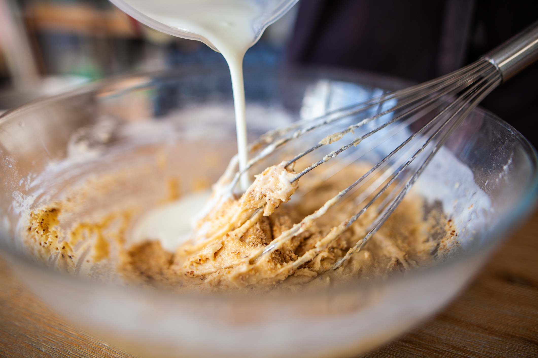 Pouring milk into batter.