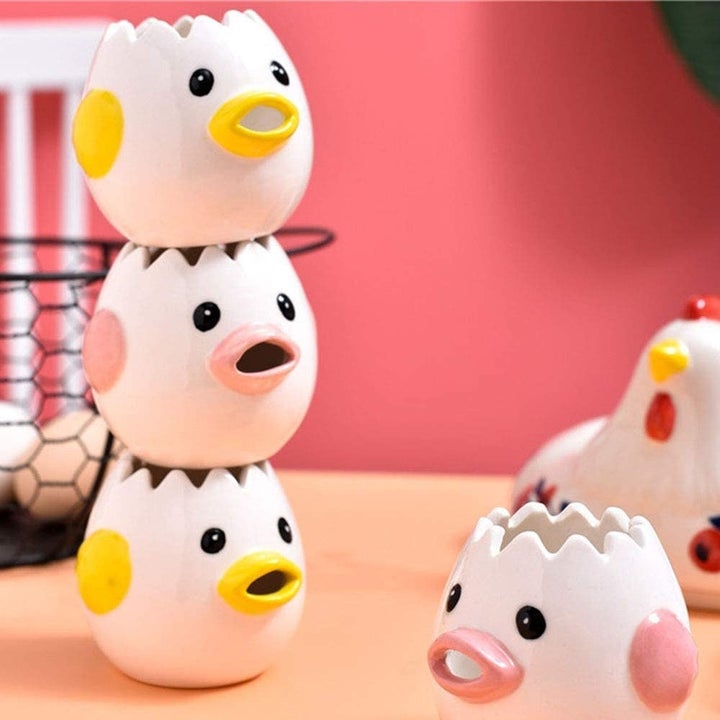 several creative cartoon ceramic chicken egg yolk separators stacked on top of one another