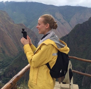 Reviewer wears yellow wind and waterproof rain jacket on a hike in Peru
