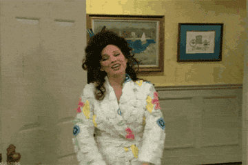 a gif zooming in on Fran Fine in &quot;The Nanny&quot; as she smiles and raises her arms 
