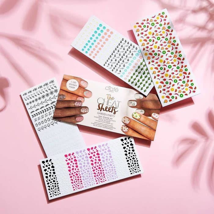 Four sheets of nail stickers on a pastel background
