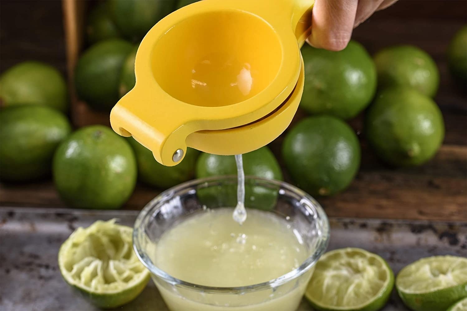 person squeezing lime juice in a glass